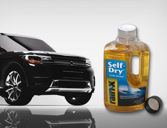 Automotive fluid bottle beside a vehicle
